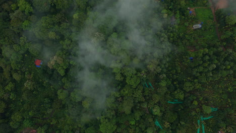 Vista-Aérea-Lejana-De-Una-Densa-Selva-Tropical,-Montañas-De-Vegetación-Y-Nubes-Brumosas,-Vistas-Reales-De-Munnar,-Kerala,-India.