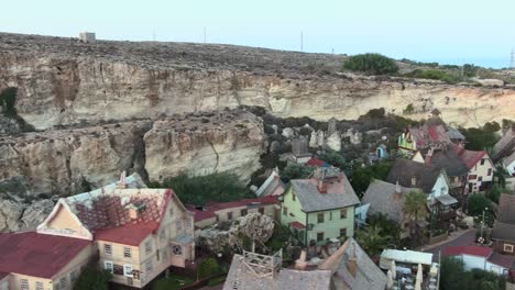 aerial-view-of-the-Beautiful-old-movie-set-with-colorful-wrecked-houses,-Popeye-village,-drone-ascending-shot