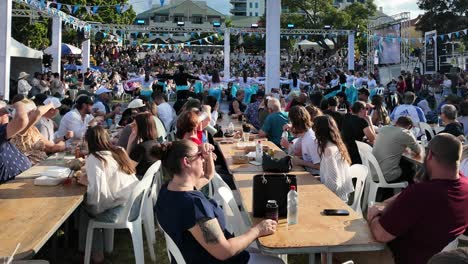 Una-Gran-Multitud-Disfruta-De-Comida-Griega-Mientras-Ve-Un-Espectáculo-De-Danza-En-El-Festival-Griego-Paniyiri-En-Brisbane,-Australia.