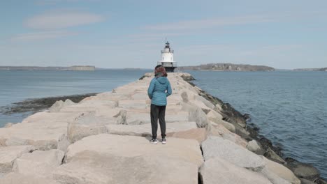 Frau-Zu-Fuß-In-Richtung-Spring-Point-Ledge-Light-House-Am-Ende-Eines-Felspiers-Am-Atlantischen-Ozean