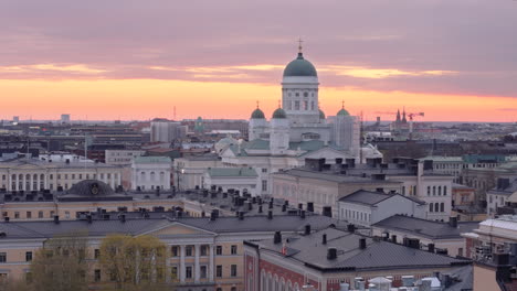 Iconic-Helsinki-cathedral-on-city-skyline-during-golden-hour,-aerial-trucking