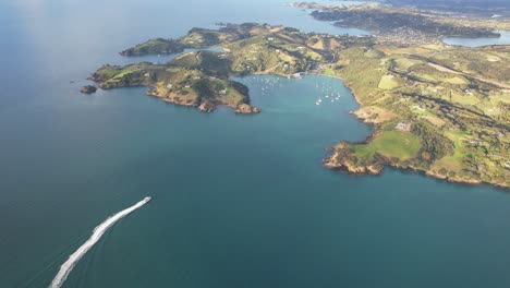 Aerial-View-Of-Ferry-Cruising-Matiatia-Bay-In-Auckland,-New-Zealand---Drone-Shot