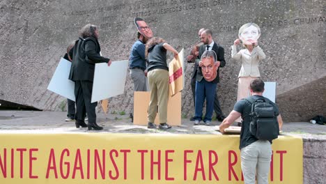 Activists-wearing-masks-of-far-right-politicians-Marine-Le-Pen,-Mateusz-Morawiecki,-Santiago-Abascal,-Viktor-Orbán,-and-Giorgia-Meloni-participate-in-a-protest-against-the-extreme-right-and-fascism