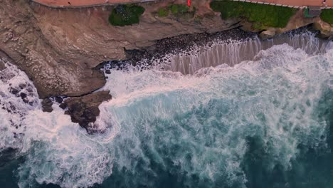 La-Jolla-Cove-Drone-High-Angle-Top-Down-Flight-Over-Rocky-cliff-making-transition-to-park-setting