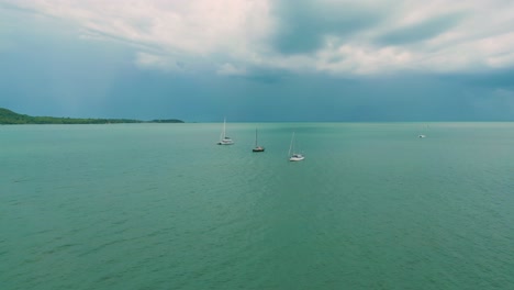 4K-Cinematic-nature-drone-footage-of-a-panoramic-aerial-view-of-boats-next-to-the-beautiful-beaches-and-mountains-on-the-island-of-Koh-Lanta-in-Krabi,-South-Thailand,-on-a-sunny-day