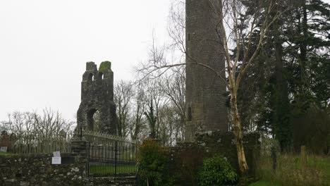 Round-tower-and-stone-ruins-at-Donaghmore-Cemetery-in-County-Meath,-Ireland,-captured-on-an-overcast-day