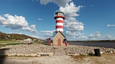 Port-of-Grafton-Lighthouse-with-American-Flags-at-the-Entrance,-Dolly-Shot