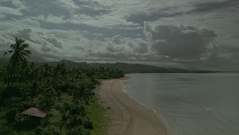 Antena-Delantera-A-Lo-Largo-De-La-Playa-De-Arena-Por-Un-Paisaje-Verde-En-Filipinas