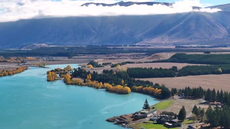 Lake-Ruataniwha-lined-by-Autumn-trees-and-high-New-Zealand-mountains