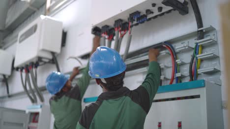 Pakistani-workers-fixing-solar-inverters-in-textile-industry-of-Pakistan