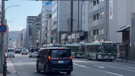 Paradas-De-Autobús-De-La-Ciudad-De-Kioto-Y-Transporte-Público-Mientras-Los-Coches-Pasan-Al-Mediodía-En-Japón