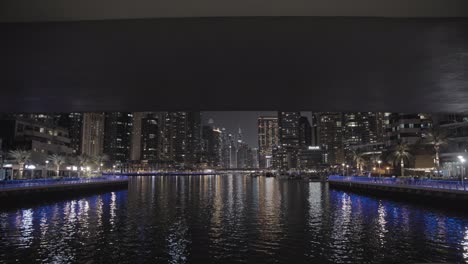 Crucero-Nocturno-Por-El-Canal-Del-Puerto-Deportivo-De-Dubai,-Que-Revela-El-Impresionante-Horizonte