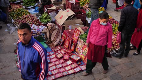 Close-elevated-shot-of-people-walking-past-market-stalls,-Bhaktapur,-Kathmandu-Valley,-Nepal