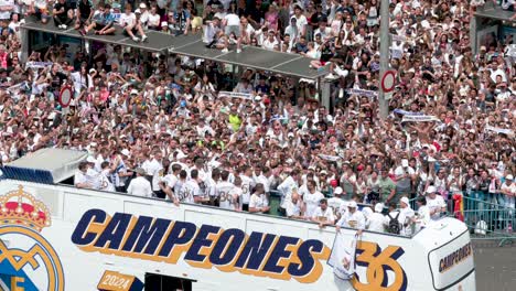 Riding-on-a-bus,-Real-Madrid-soccer-players-celebrate-winning-the-36th-Spanish-soccer-league-title,-the-La-Liga-trophy,-at-Cibeles-Square,-where-thousands-of-fans-in-Madrid,-Spain