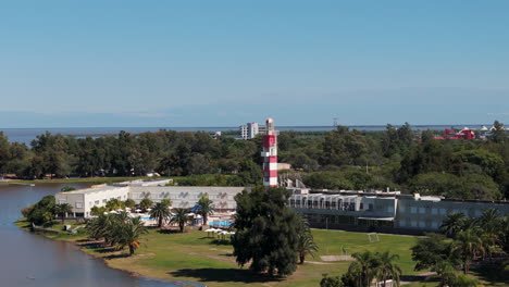 A-drone-circles-around-a-lighthouse-at-a-luxury-hotel-in-Termas-de-Río-Hondo,-capturing-its-elegant-architecture-and-scenic-surroundings