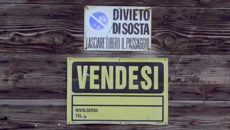 Zoomen-Auf-Ein-Italienisches-„Zu-Verkaufen“-Schild-Und-Ein-Italienisches-„Parkverbot“-Schild,-Das-Auf-Alten-Rustikalen-Holzbrettern-Befestigt-Ist