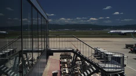 Avión-Hk-Express-En-La-Pista-Reflejándose-En-El-Cristal-De-La-Terminal