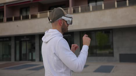 Male-engages-with-a-virtual-world-using-a-mixed-reality-spacial-computer-headset,-using-gestures-such-as-pinching-with-fingers