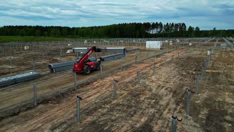 Aerial-view-following-a-machine-carrying-material-at-a-solar-park-construction-site