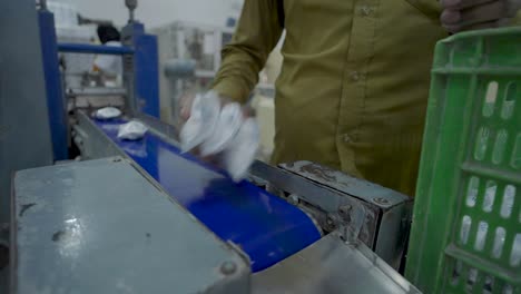 Kein-Gesichtsvideo-Eines-Mitarbeiters,-Der-Verpackte-Seifen-Vom-Förderband-Einer-Seifenfabrik-In-Pakistan-Nimmt