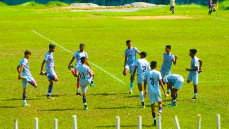 Jugadores-De-Fútbol-Realizando-Ejercicios-De-Calentamiento-Antes-Del-Partido-En-Sylhet,-Bangladesh---Plano-Amplio