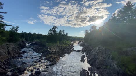 Drone-shot-of-a-lake-running-through-the-rocks-in-the-forest