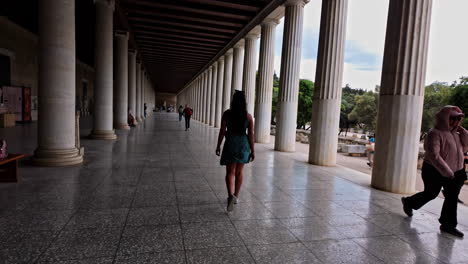 Mujer-Joven-Caminando-En-La-Estoa-De-Attalos,-Museo-Del-ágora-Antigua-Atenas,-Grecia