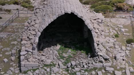 flight-in-retreat-and-ascent-with-a-drone-in-the-hermitage-of-San-Pedro-14th-century-where-we-see-its-impressive-vaulted-ceiling-of-large-chiseled-granite-stones,-there-are-many-remains-on-the-floor