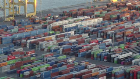 Huge-area-of-the-port-of-Barcelona-filled-with-cargo-containers,-cargo-truck-driving-through-the-containers