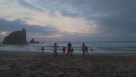 Happy-women-dancing-with-feet-in-the-sea-at-sunset