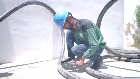 Side-view-of-workers-cutting-thick-pipes-inside-a-textile-industry-in-Pakistan