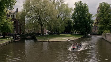 Paseo-En-Barco-Por-El-Canal-Con-Exuberante-Follaje-En-Brujas,-Bélgica