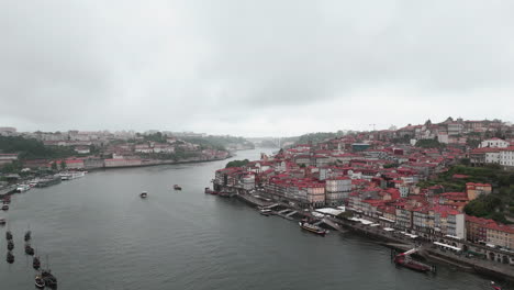 Aerial-shot-of-Porto's-riverside-under-cloudy-skies,-Portugal