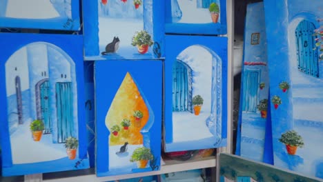 Mujer-Mirando-Pinturas-Souvenir-En-Una-Tienda-De-Chefchaouen.