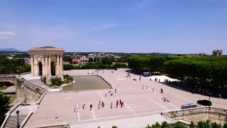 Aerial-orbiting-shot-of-kids-paying-sports-at-the-Promenade-du-Peyrou