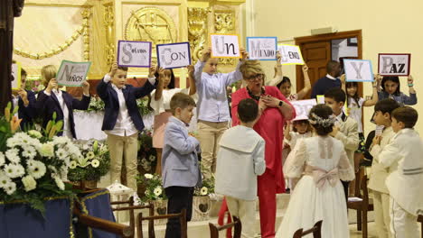 Niños-Presentan-Una-Canción-De-Acción-Durante-Su-Ceremonia-De-Primera-Comunión-En-Una-Iglesia-Católica-En-Zaragoza,-España---Plano-Medio