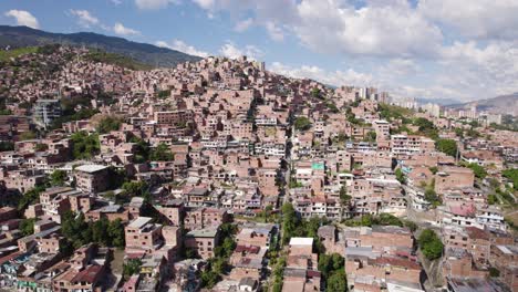 Multi-family-homes-crowd-mountainside-favela-in-Medellin-Colombia,-aerial-establish