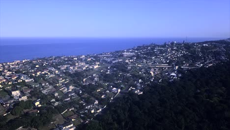 Drohne-Fliegt-über-Einige-Wohnhäuser-Und-Eine-Grundschule-Mit-Meerblick-Im-Hintergrund-Am-Bluff-Brighton-Beach