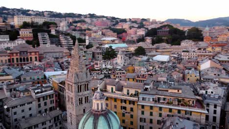 Genoa's-historical-center-at-sunset,-showcasing-colorful-buildings-and-busy-streets,-aerial-view