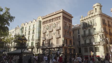 Pedestrians-walking-in-busy-city-center-street-of-Barcelona-with-scenic-architectural-residential-buildings