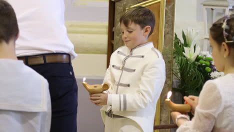 A-boy-in-white-uniform-participates-in-a-Spanish-Communion-ceremony-in-Zaragoza,-Spain