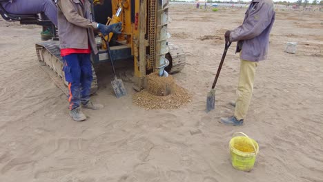 Operator-digging-with-pile-driver-rig-for-solar-farm-concrete-piles-in-Jambur,-Gambia---West-Africa