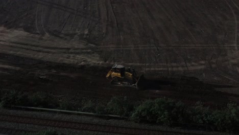 Bulldozer-Bewegt-Erde-Und-Schafft-Ein-Fundament-Für-Eine-Straße.-Luftbild-Tracking-Ansicht-Auf-Der-Baustelle-Mit-Sonnenaufgang-Am-Frühen-Morgen