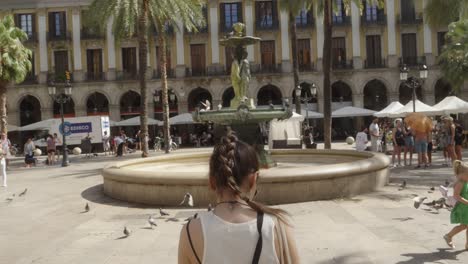 Female-tourist-taking-pictures-at-Plaça-Reial-in-Barcelona