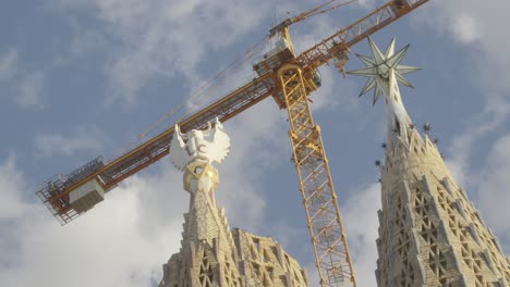 Low-angle-view-of-tall-yellow-crane-outside-of-the-Sagrada-Familia-towers-in-Barcelona-city-center