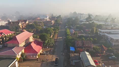 Vista-Aérea-Por-Drones-De-Las-Concurridas-Calles-De-Antsirabe,-La-Tercera-Ciudad-Más-Grande-De-Madagascar,-En-Una-Mañana-Soleada-Con-Niebla