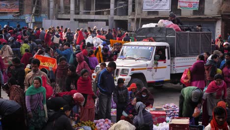 Toma-Elevada-De-Un-Camión-Conduciendo-Lentamente-A-Través-De-Un-Mercado-En-Una-Plaza-De-La-Ciudad,-Bhaktapur,-Valle-De-Katmandú,-Nepal.