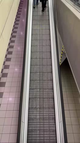 People-on-an-escalator-moving-upwards-to-shopping-mall-entrance