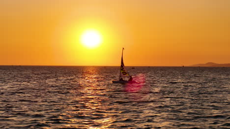 Pequeño-Velero-Ligero-Navegando-A-Través-De-Un-Hermoso-Horizonte-Al-Atardecer