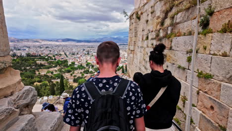 Athens-cityscape-view-from-Monument-of-Agrippa,-touristic-group-descend-the-stairs-of-Acropolis